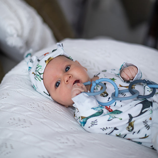 Baby Boy Welcome Hamper featuring a baby in a printed outfit and knitted cap, a thoughtful new baby gift with same-day delivery across Australia