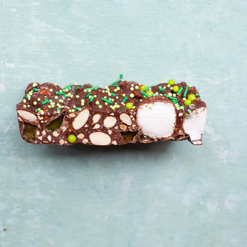 Mint Motorway Rocky Road chocolate slice with marshmallows nuts and green sprinkles on a blue background for sweet treat gifting
