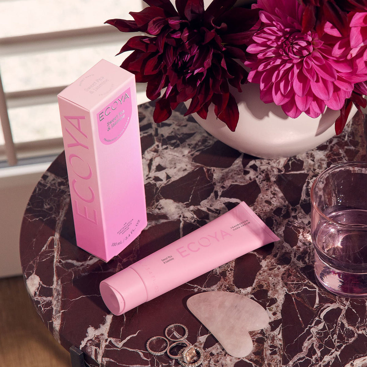 Sweet Pea Jasmine Hand Cream in pink packaging styled with dark pink flowers and self care accessories from Flowers for Everyone