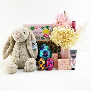 Easter hamper with flowers and stuffed bunny toy.