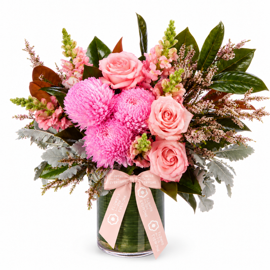 Hello Baby Vase with pink roses, chrysanthemums, delicate filler flowers and lush greenery in a clear glass vase, ideal for new baby flowers