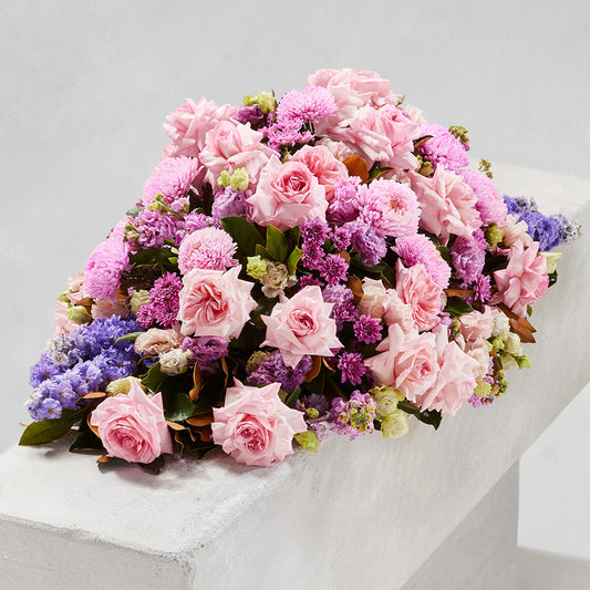 MODERN SPRING CASKET with pink roses chrysanthemums and purple flowers for funeral sympathy flowers and same day delivery