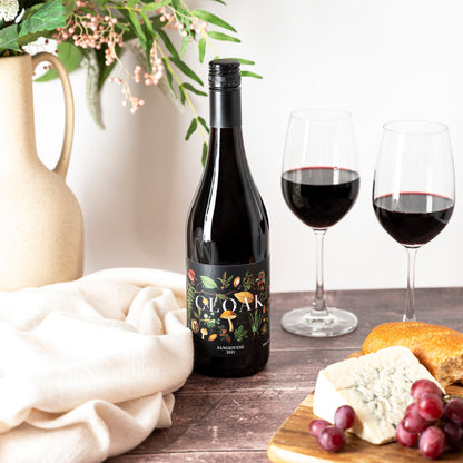 Cloak & Dagger Sangiovese Red Wine bottle with two glasses, cheese and grapes on a table, a thoughtful gift from the Wine and All gifts collections
