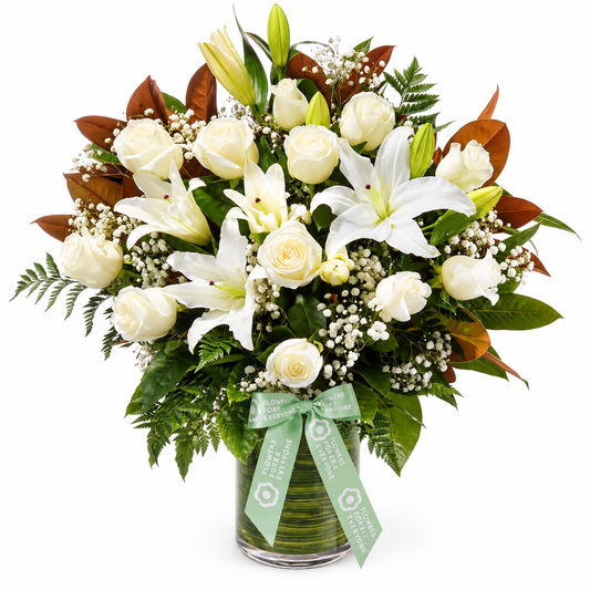 Garden Rose and Lily Vase featuring white roses and lilies with delicate filler flowers lush greenery and a ribbon for sympathy or congratulations gifting