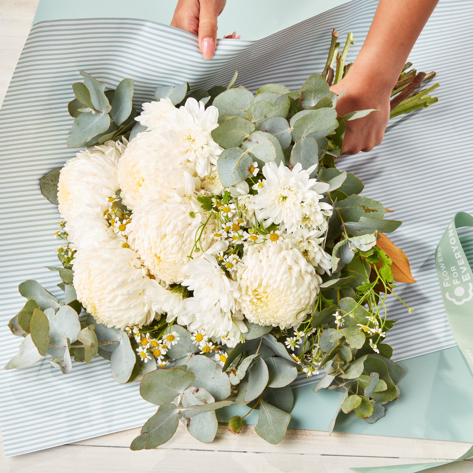 Soft Ivory Bouquet with white chrysanthemums eucalyptus and delicate daisies wrapped for sympathy flowers
