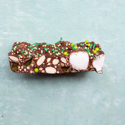 Mint Motorway Rocky Road chocolate slice with marshmallows nuts and green sprinkles on a blue background for sweet treat gifting